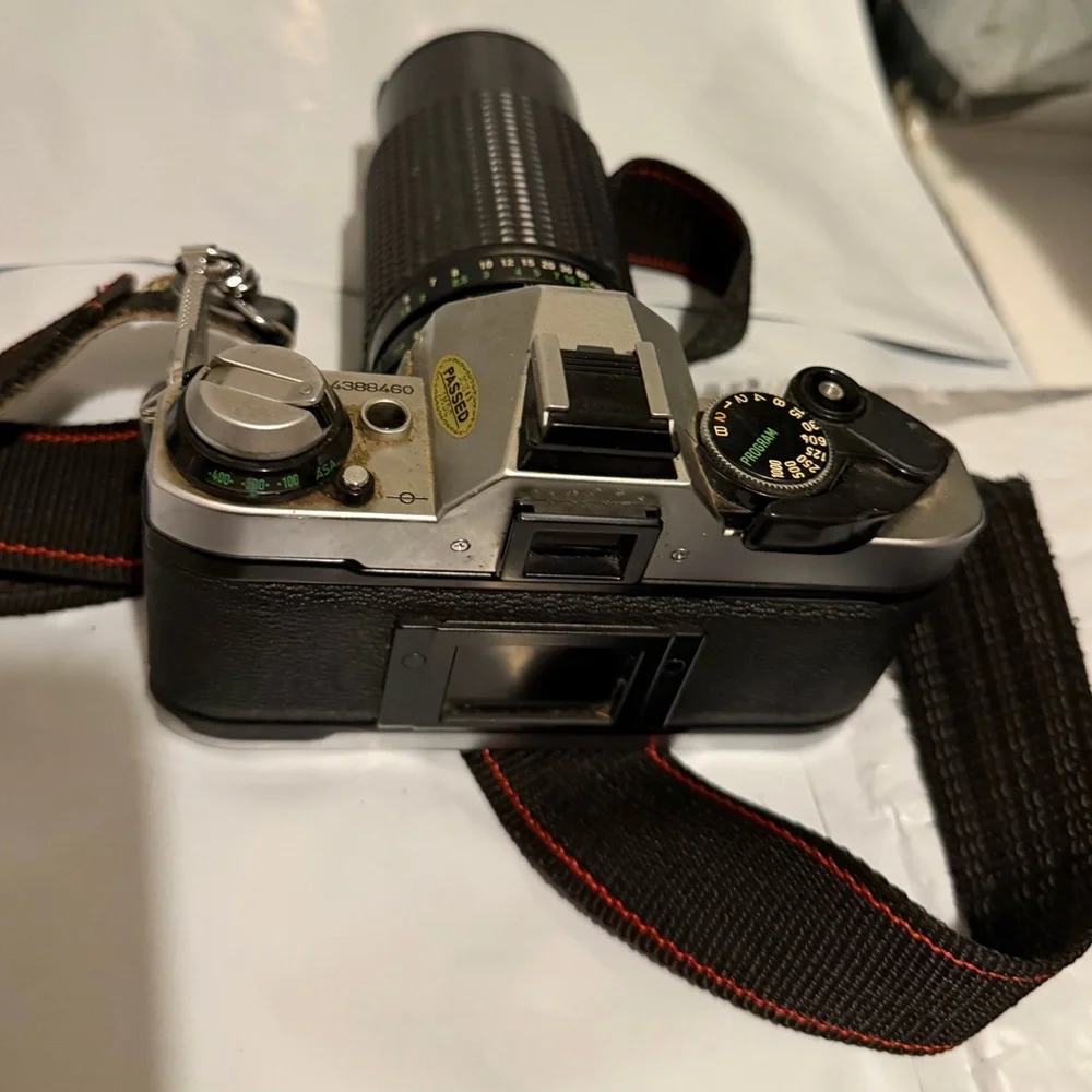 Canon silver and black SLR camera with black telephoto lens